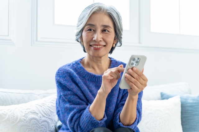 スマホを使いこなす白髪の女性
